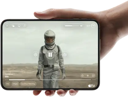 iPhone Duo, tenu à une main, ouvert en position horizontale, entièrement déplié, l’écran interne affichant la série Apple TV « Silo »